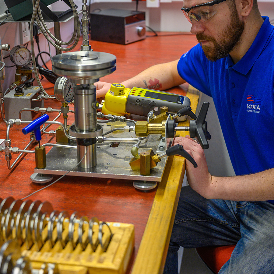 Scotia Instrumentation technician with deadweight tester and Druck calibrator in the UKAS pressure laboratory